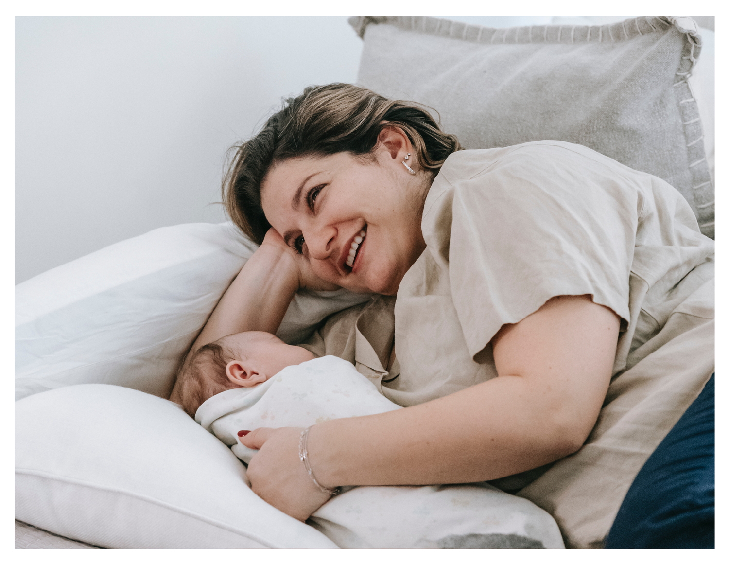 Happy mother laying with her new baby.