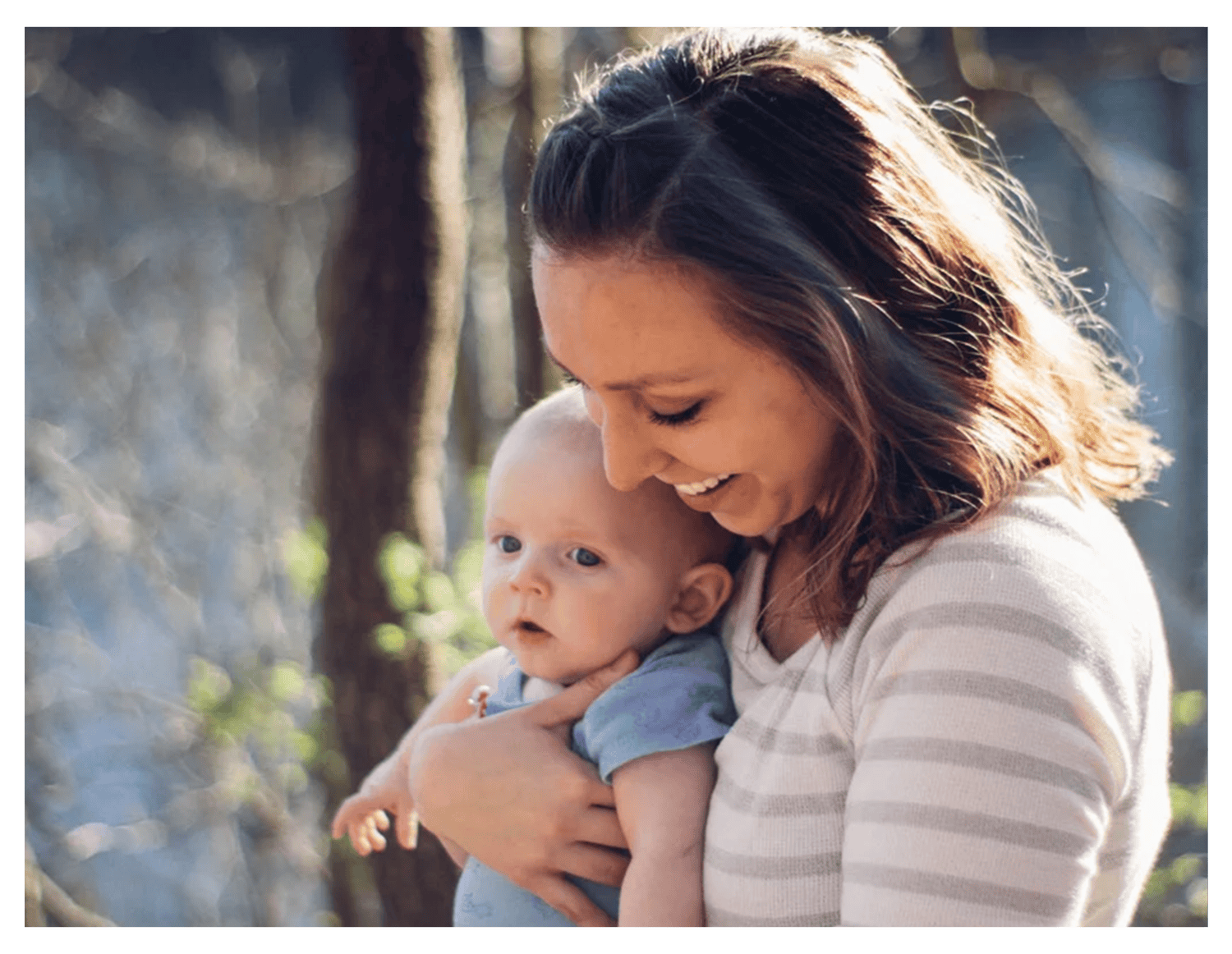 A woman happily holding her baby.